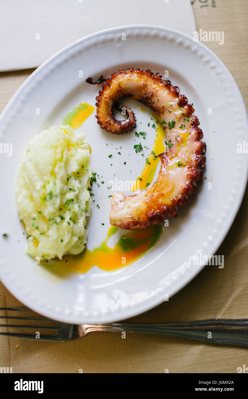 Grilled octopus with potato puree and paprika oil, selective focus, from above Stock Photo