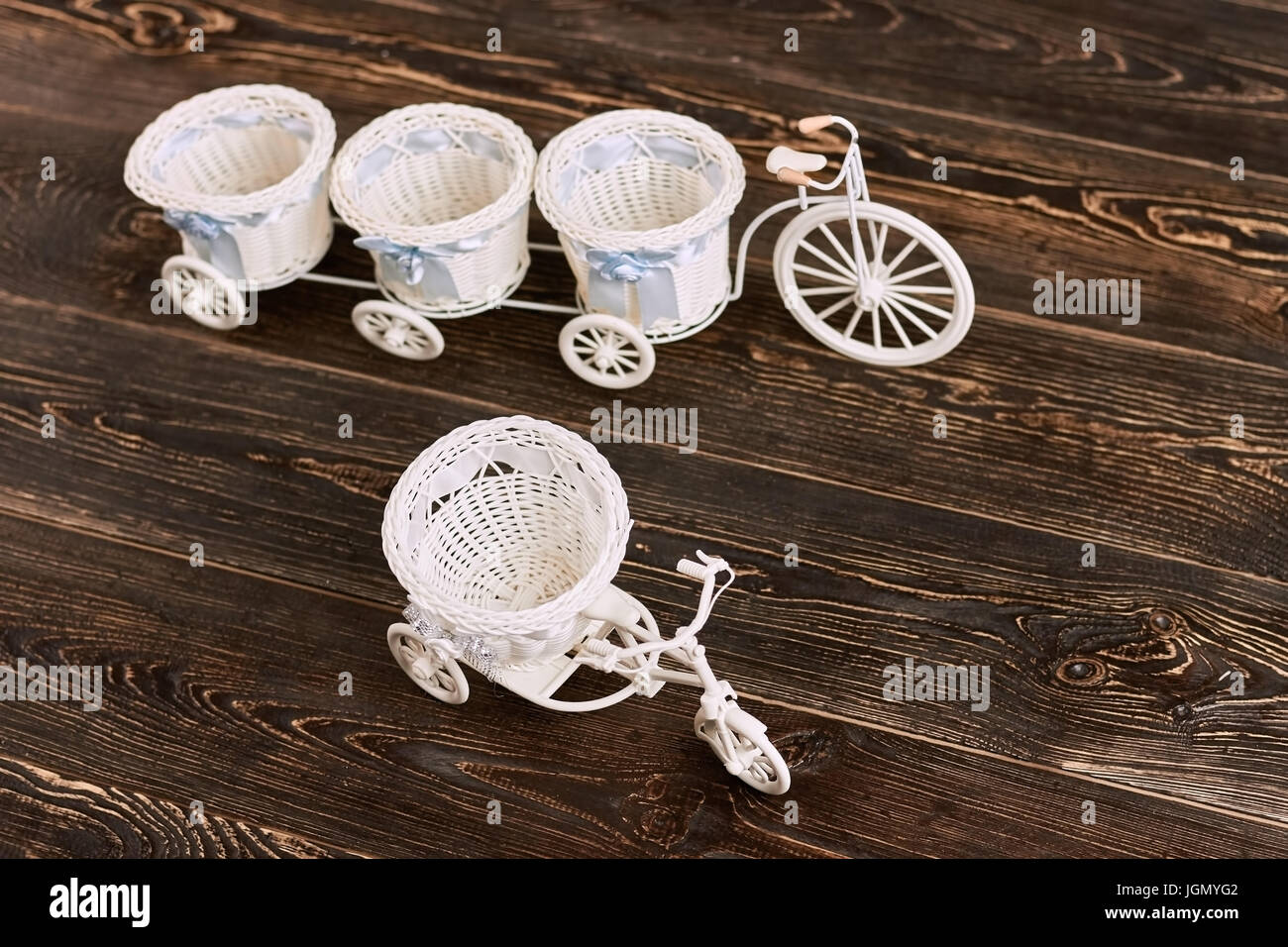 Tricycle flower baskets on wood. White plastic toys. Cheap home ...
