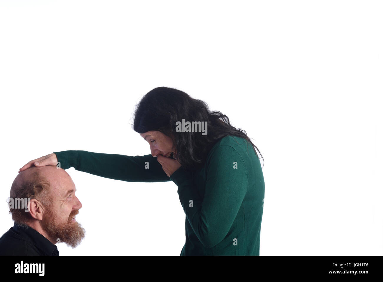 woman teasing a bald man Stock Photo