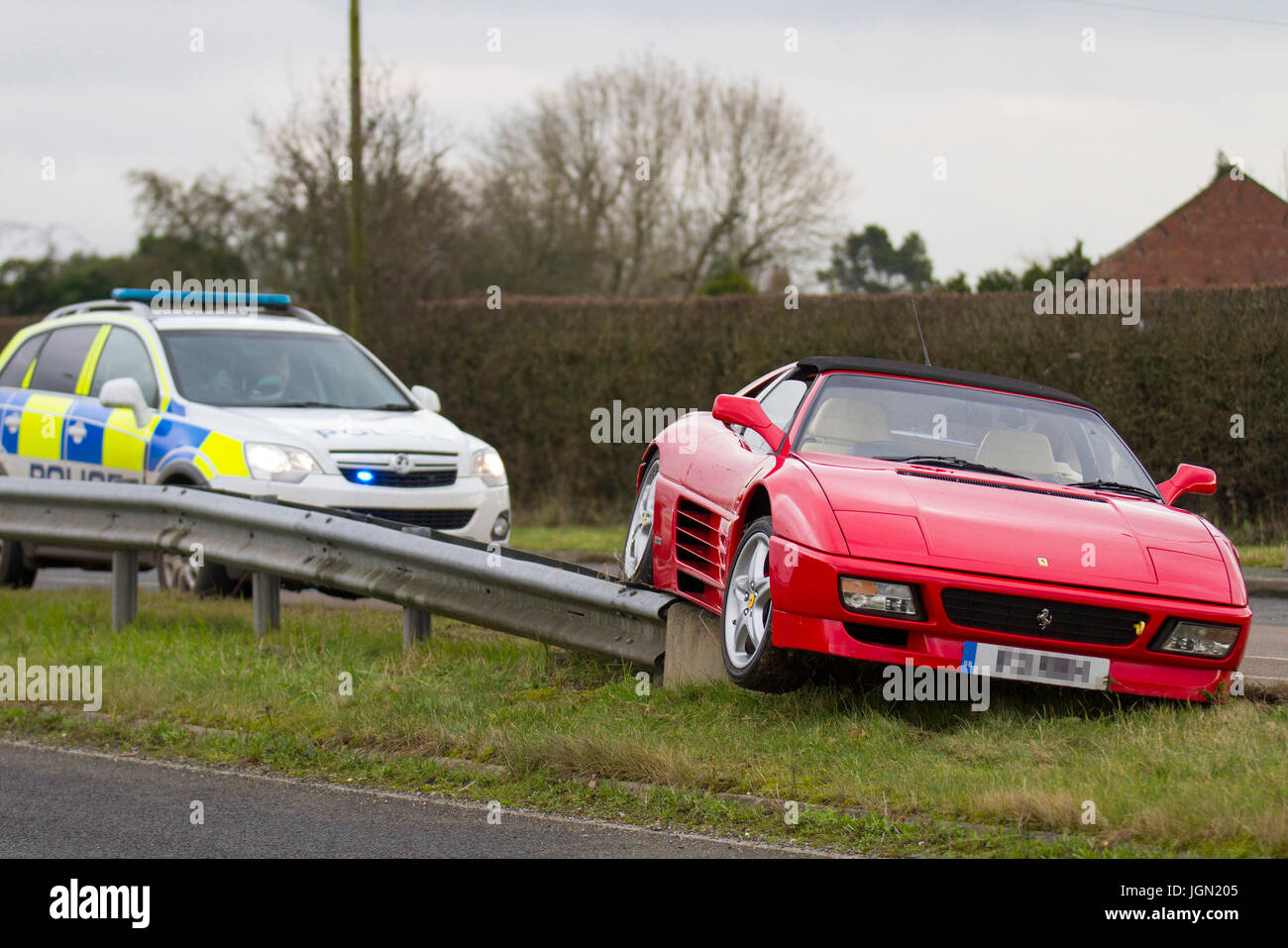 Ferrari 348 TS. crashed in Tarleton, Lancashire.  UK Weather. Lancashire Police traffic car attends road accident where a Ferrari 348 TS. has crashed in slippery in conditions on the Tarleton Bypass.  In a 1990 Car and Driver comparison test, a 348TS was described as having 'inexcusable handling,' and as 'a terrible car to drive fast. C Stock Photo