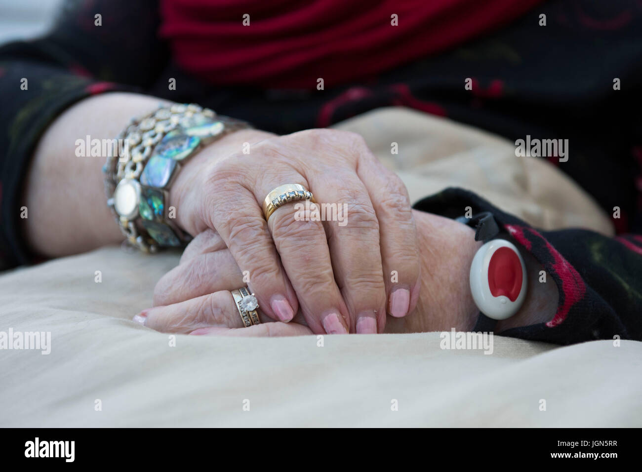 A vulnerable old age pensioner wears a panic alarm wristband. Stock Photo