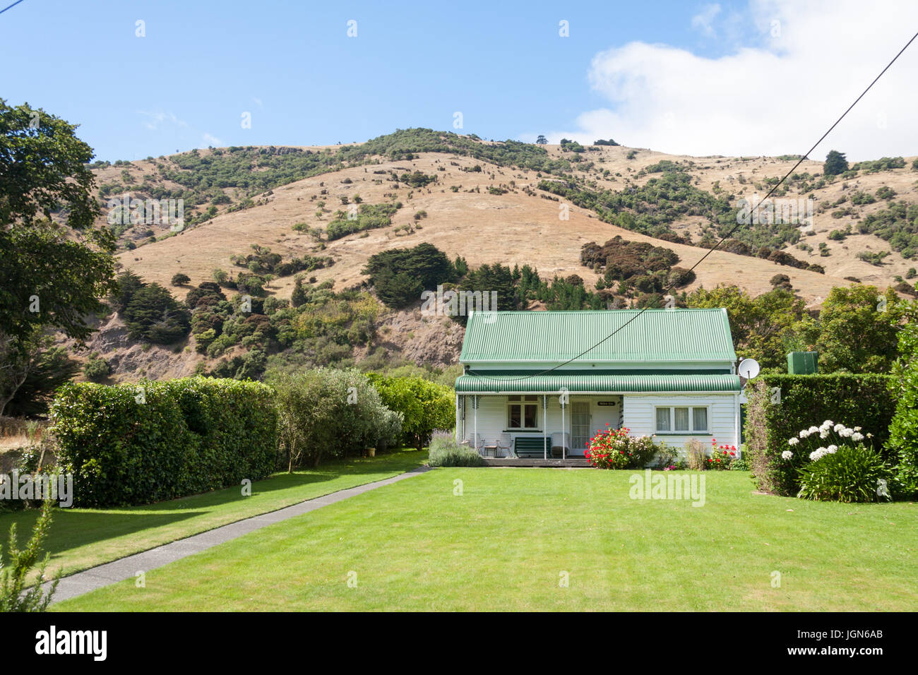 Typical house with grass lawn and garden in Okains Bay, South Island, New Zealand Stock Photo