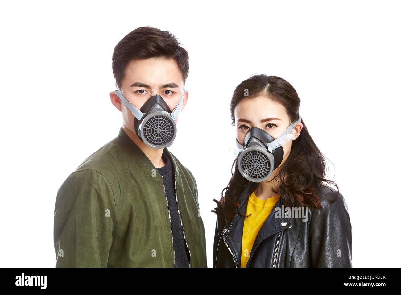 young asian couple wearing gas mask staring at camera, isolated on white background. Stock Photo