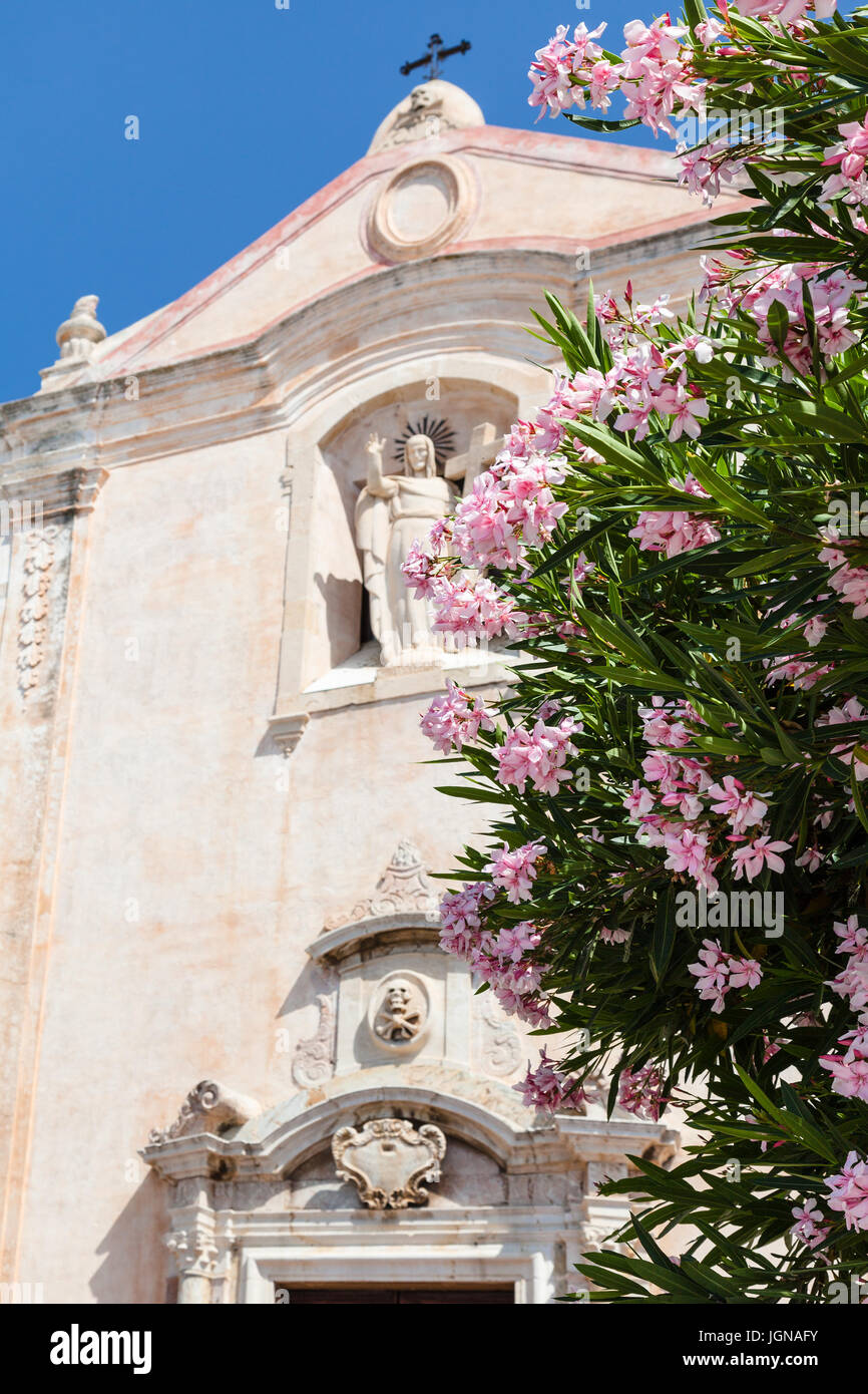 travel to Sicily, Italy - oleander tree and church Chiesa di San Giuseppe at Piazza 9 Aprile in Taormina city in summer day Stock Photo