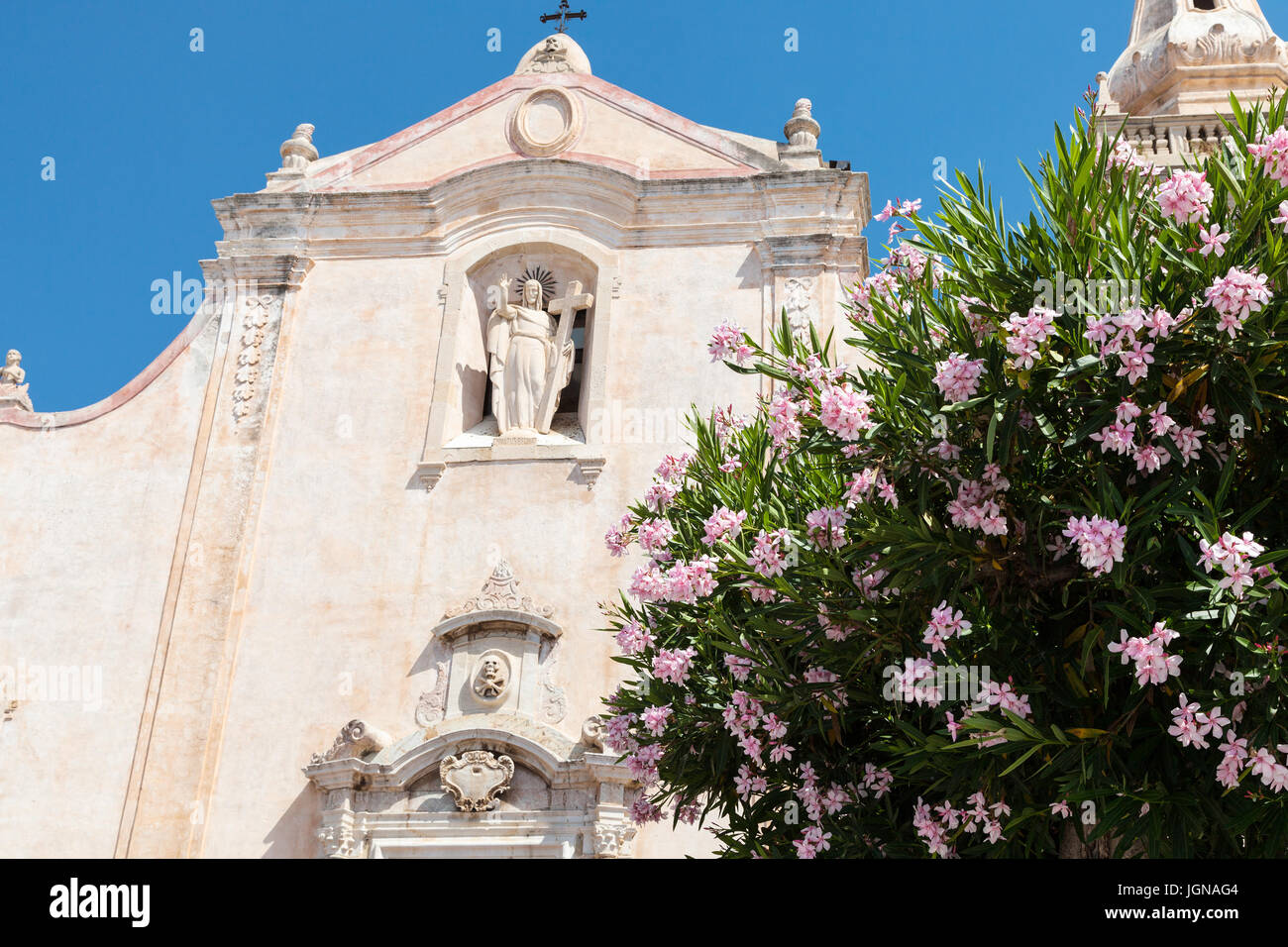 travel to Sicily, Italy - oleander tree and facade of church Chiesa di San Giuseppe at Piazza IX Aprile in Taormina city in summer day Stock Photo