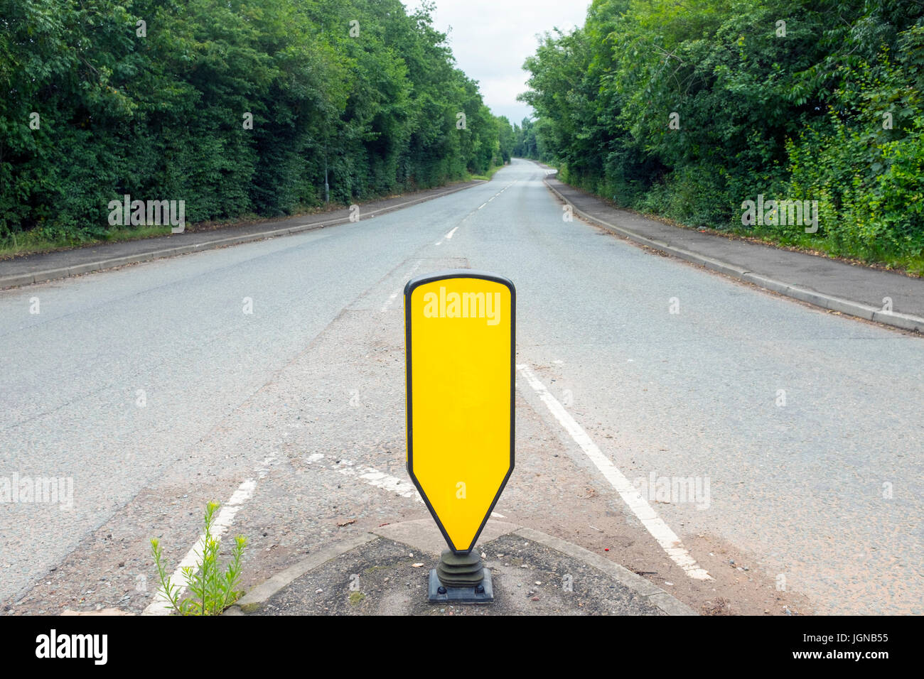 Empty road with yellow traffic sign in Cheshire UK Stock Photo