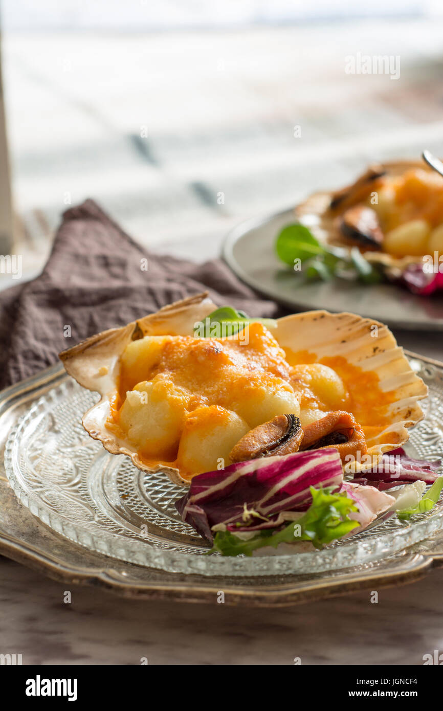 Gnocchi pasta with mussels, tomato and cream room, in vieira shell Stock Photo Alamy