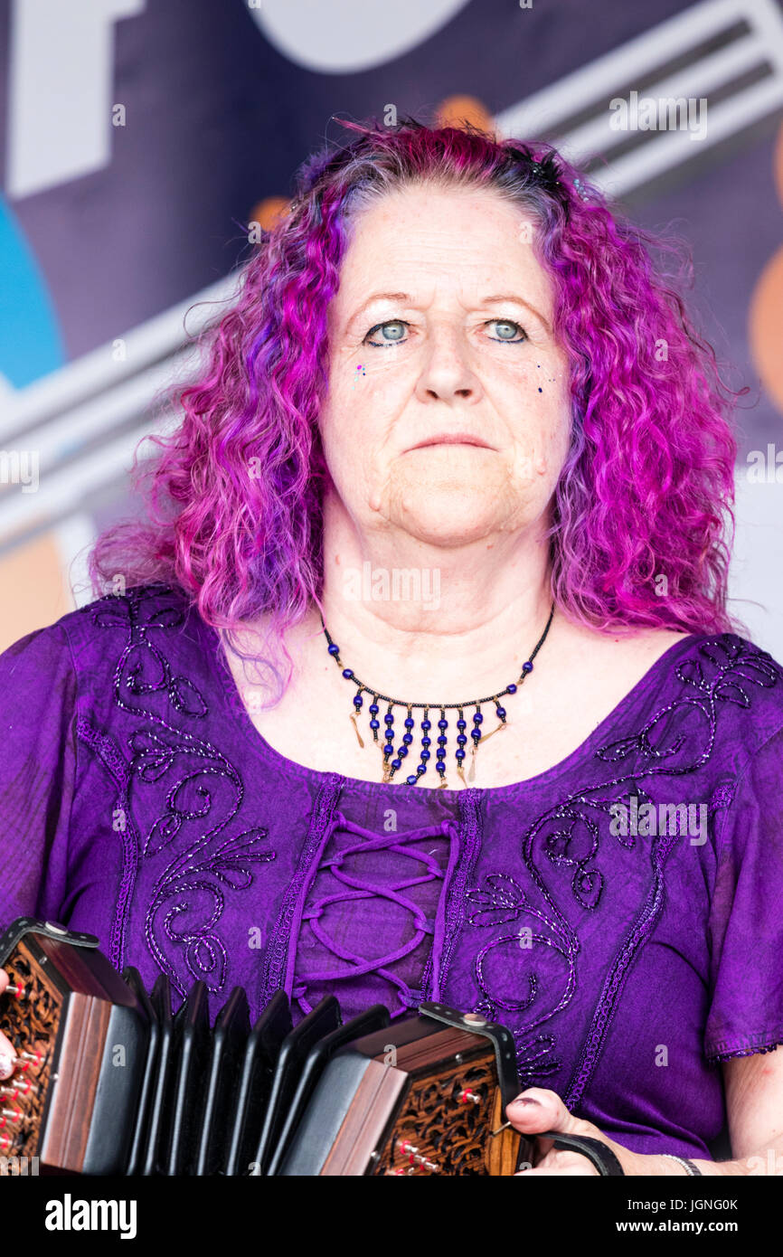 Mature woman, Caucasian, 50s, Lisa Bradley from the duo Will Allen and Lisa Bradley. Lisa is playing Anglo concertina. Mauve hair, facing, head and shoulders. Stock Photo