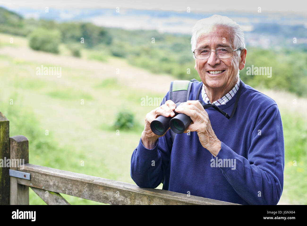 Portrait Of Senior Man On Walk With Binoculars Stock Photo