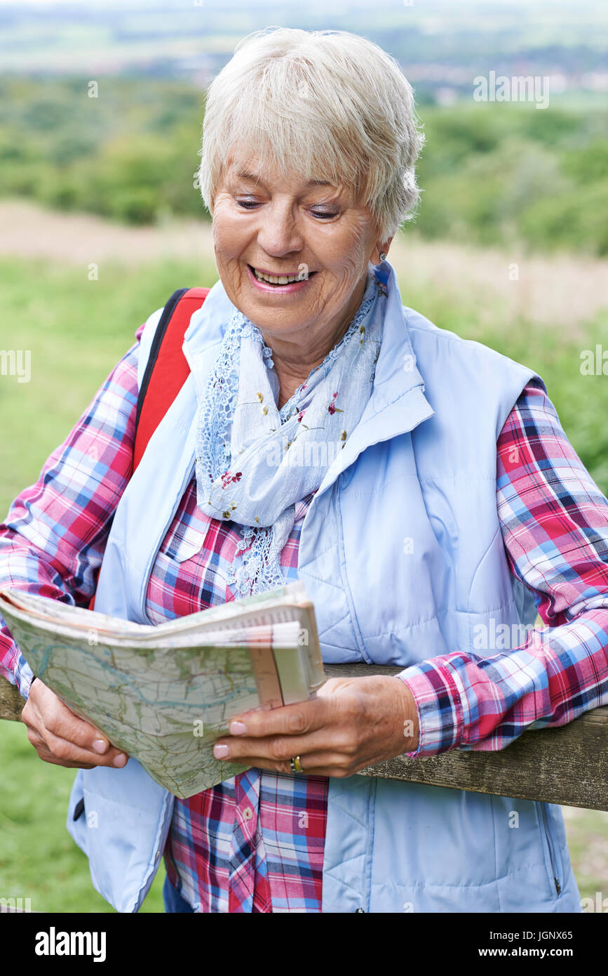 Senior Woman Hiking In Countryside With Map Stock Photo
