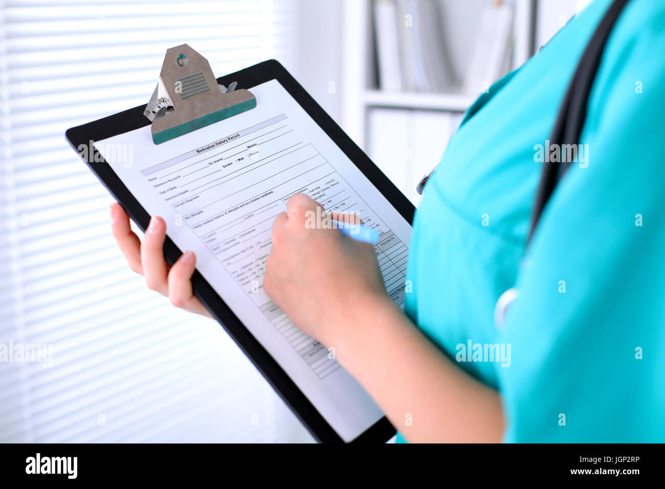 Close-up of a female doctor is filling out application form or medical ...