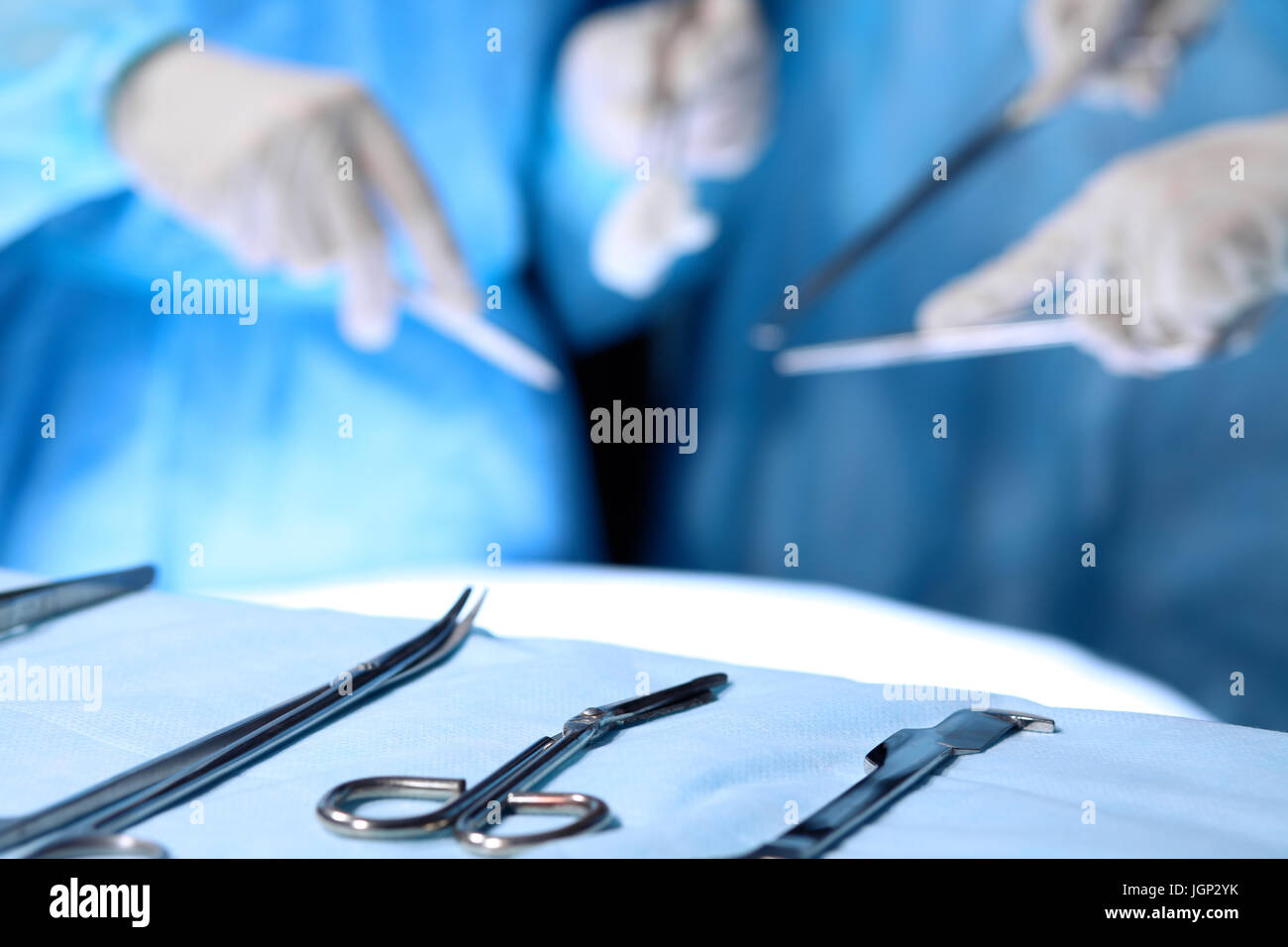 Surgical tools lying on the table while group of surgeons at background