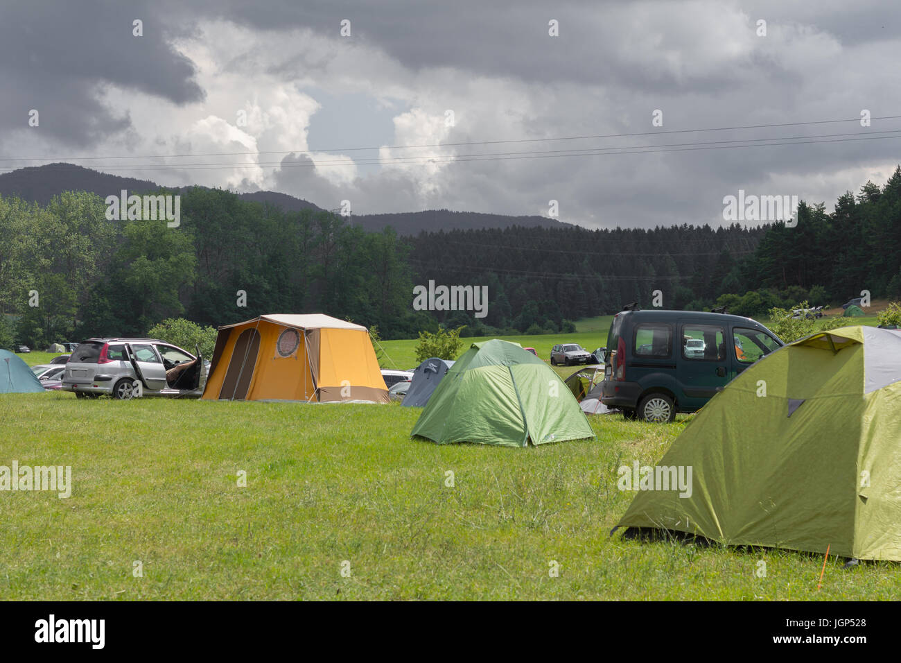 camping tents on the green summer meadow with cloudy sky Stock Photo ...