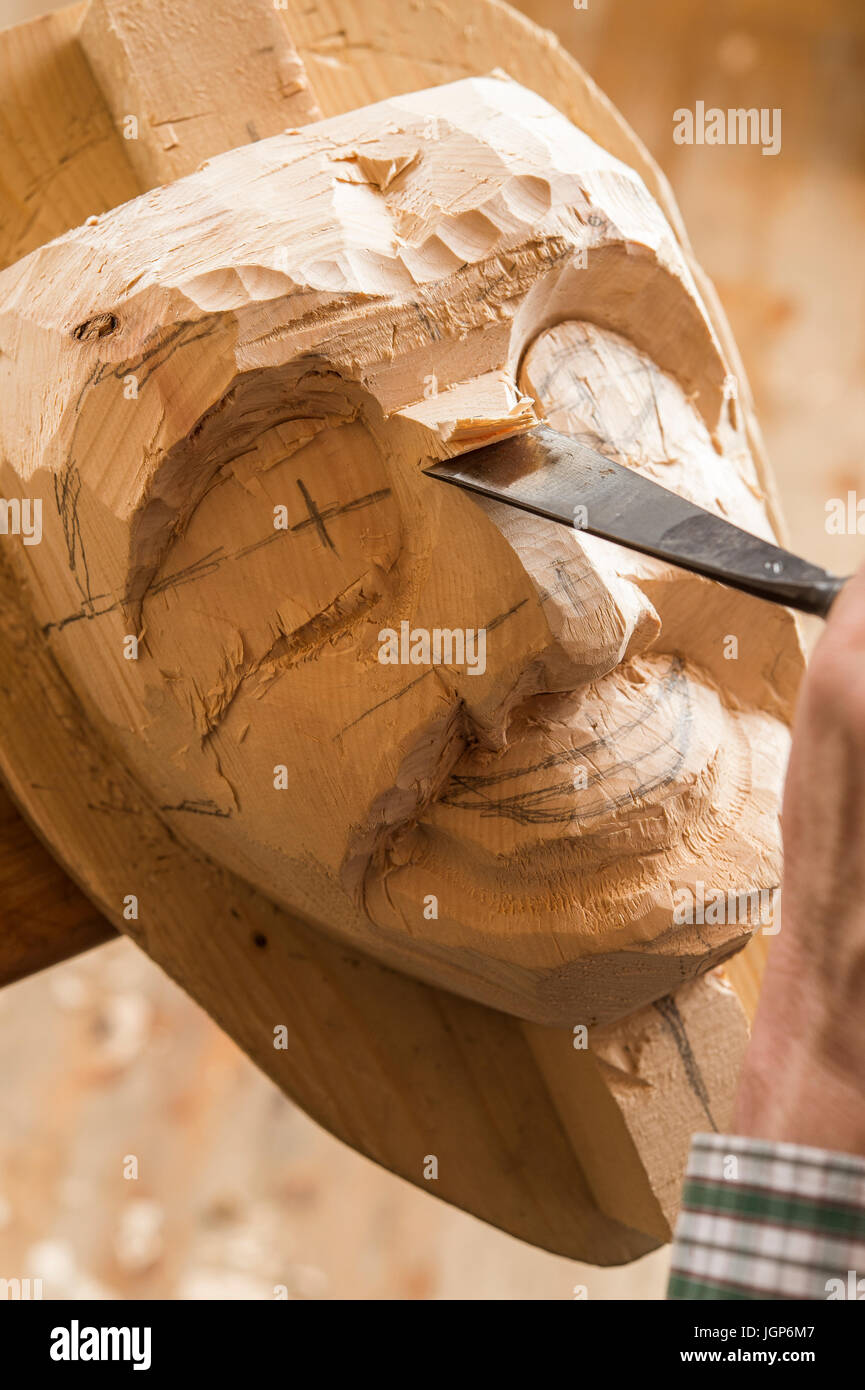 Carving the face of a wooden mask into wooden block using wood carving tools, wooden mask carver, Bad Aussee, Styria, Austria Stock Photo