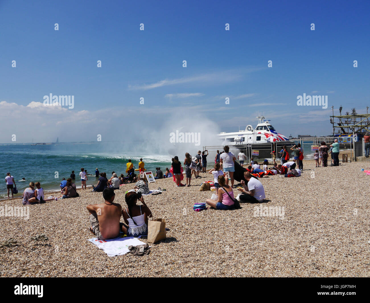 Visitors to Southsea beach, Portsmouth, enjoy a hot summers day  as a Portsmouth to Isle of Wight Hovercraft operates from the hoverport Stock Photo