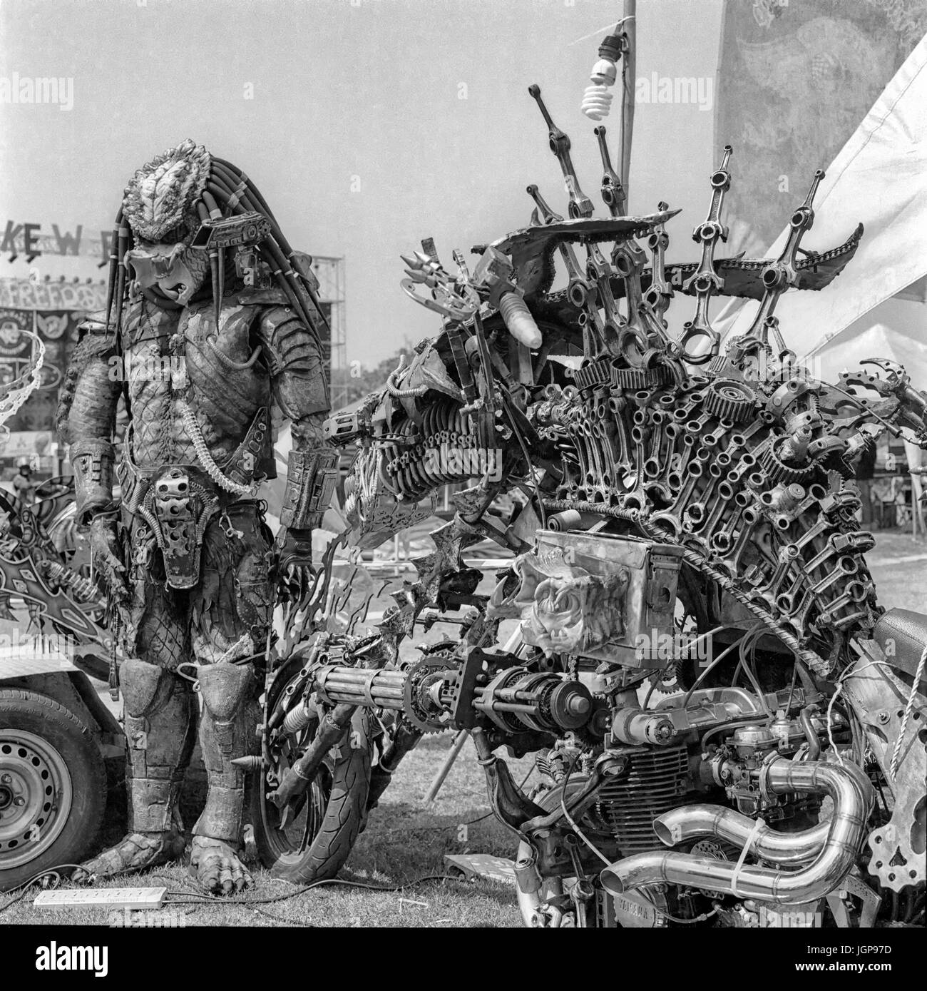 'Predator' alien movie character built of metalwork parts and featuring extreme modified motorcycle. black and white photography. Stock Photo