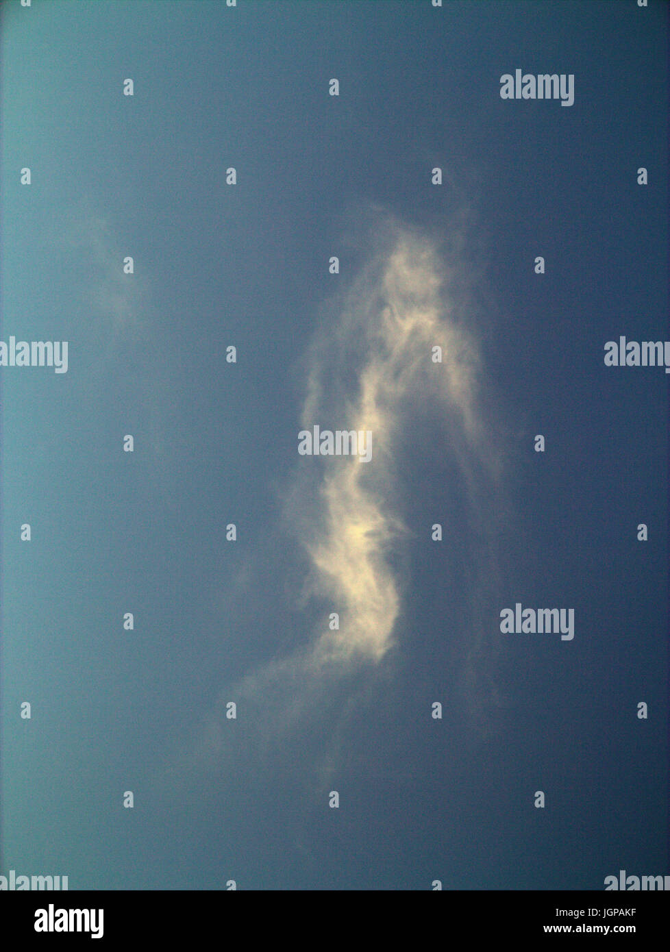 facial Pareidolia blue sky with white clouds that look like an evil devil or witch Stock Photo