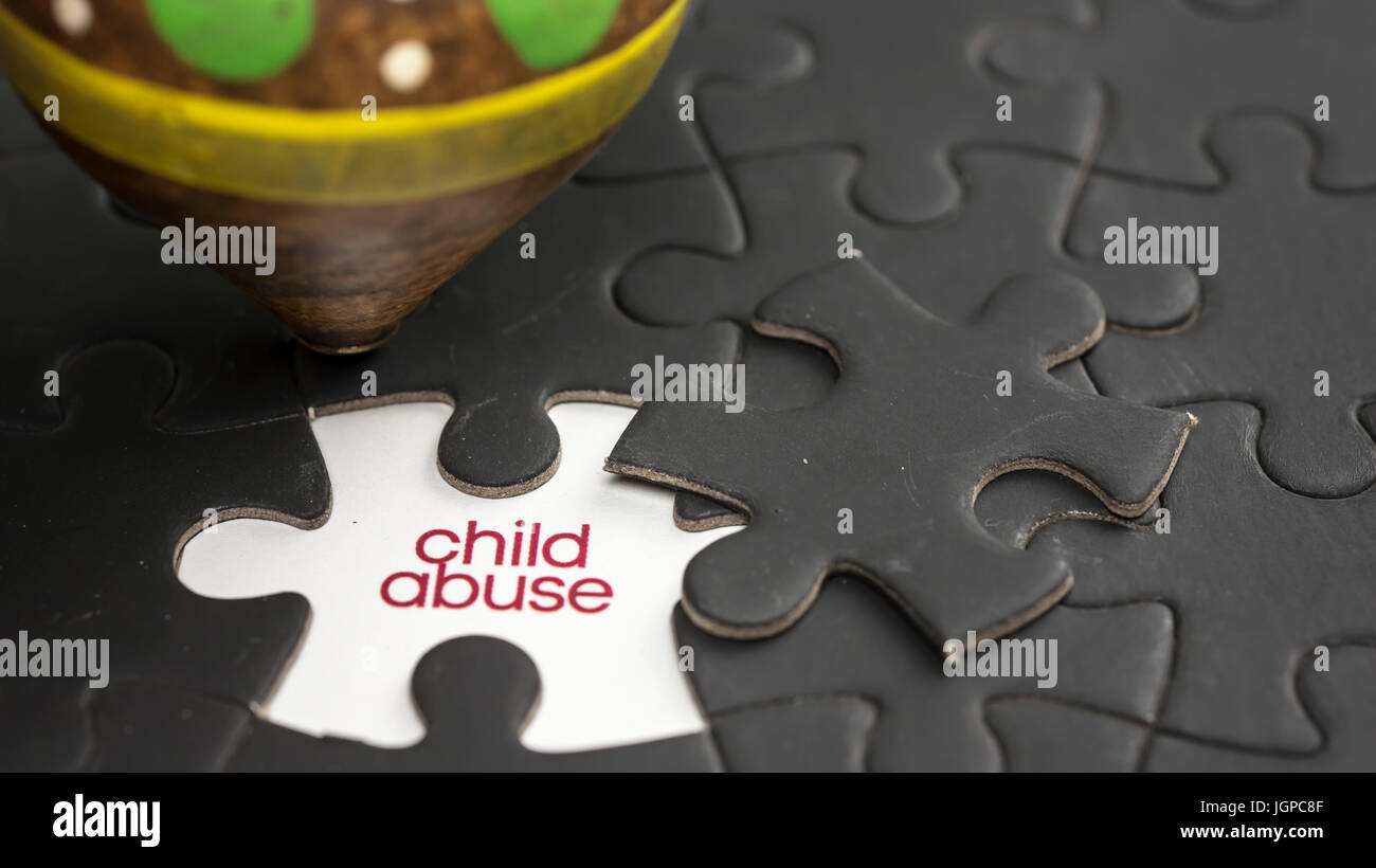 Words child abuse under jigsaw puzzle piece Stock Photo