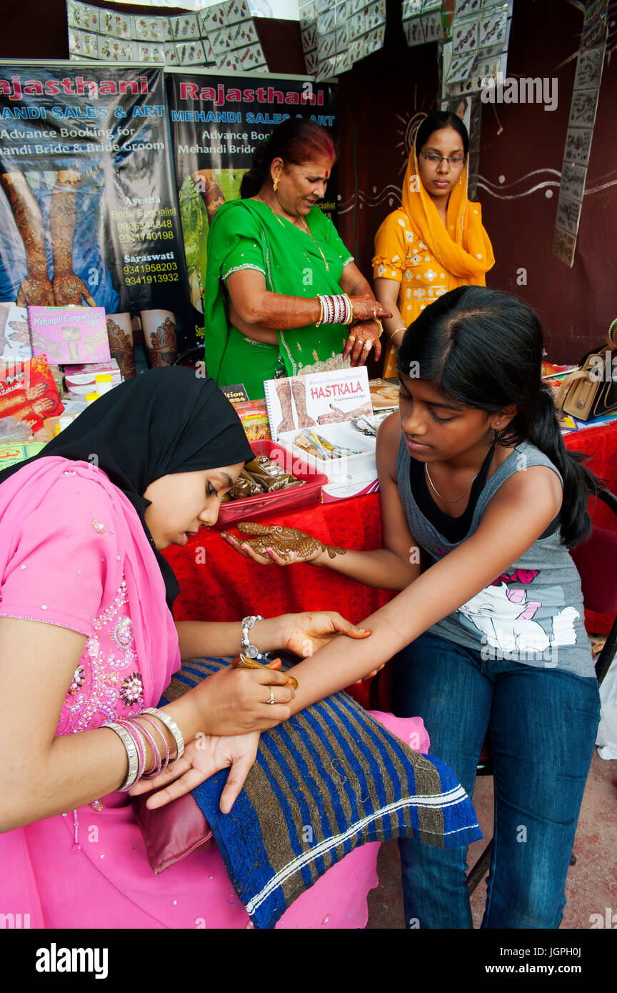 Indian young girl getting some henna work on his arm, Bangalore
