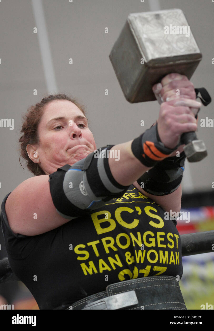 Vancouver, Canada. 9th July, 2017. An athlete competes in a strength  competition by holding a 10kg hammer in front of her chest during the BC  Provincial Strongest man & woman Championships at