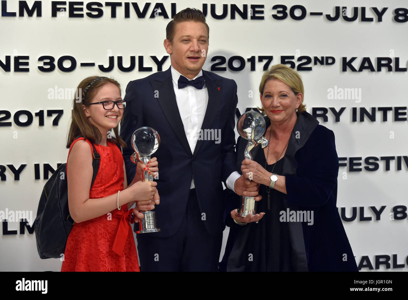Karlovy Vary, Czech Republic. 08th July, 2017. U.S. actor Jeremy Renner (centre) won Festival President's Award for a major contribution to film development at the closing ceremony in Karlovy Vary, Czech Republic, July 8, 2017. Renner is known for his role of the fictional superhero Hawkeye in The Avengers. At right is his mother. At left is daughter of Bosnian filmmaker Alen Drljevic with award. The special prize went to Men Don't Cry by Bosnian Alen Drljevic about veterans of the war in Yugoslavia and their trauma. Credit: Slavomir Kubes/CTK Photo/Alamy Live News Stock Photo