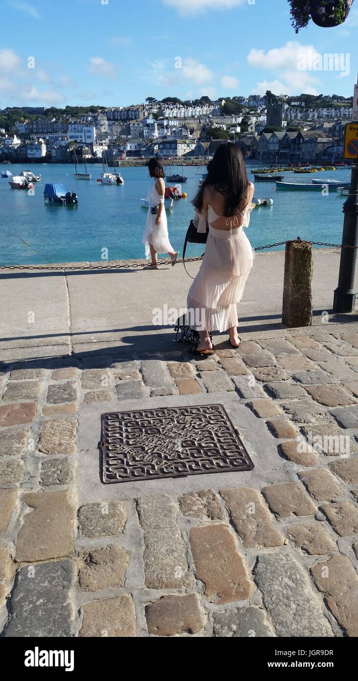 Summer dress girls pose and take photos by St Ives harbour Stock Photo