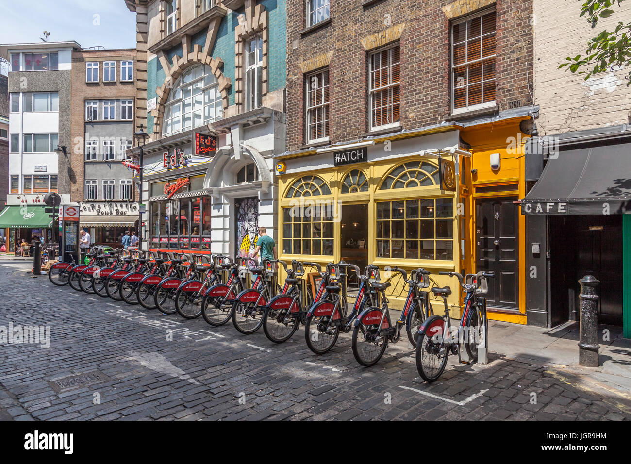 A row of Santander Cycles, aka 'Boris Bikes' - self-service bicycle-sharing scheme in Moor Street, Soho, London, England, UK. Stock Photo