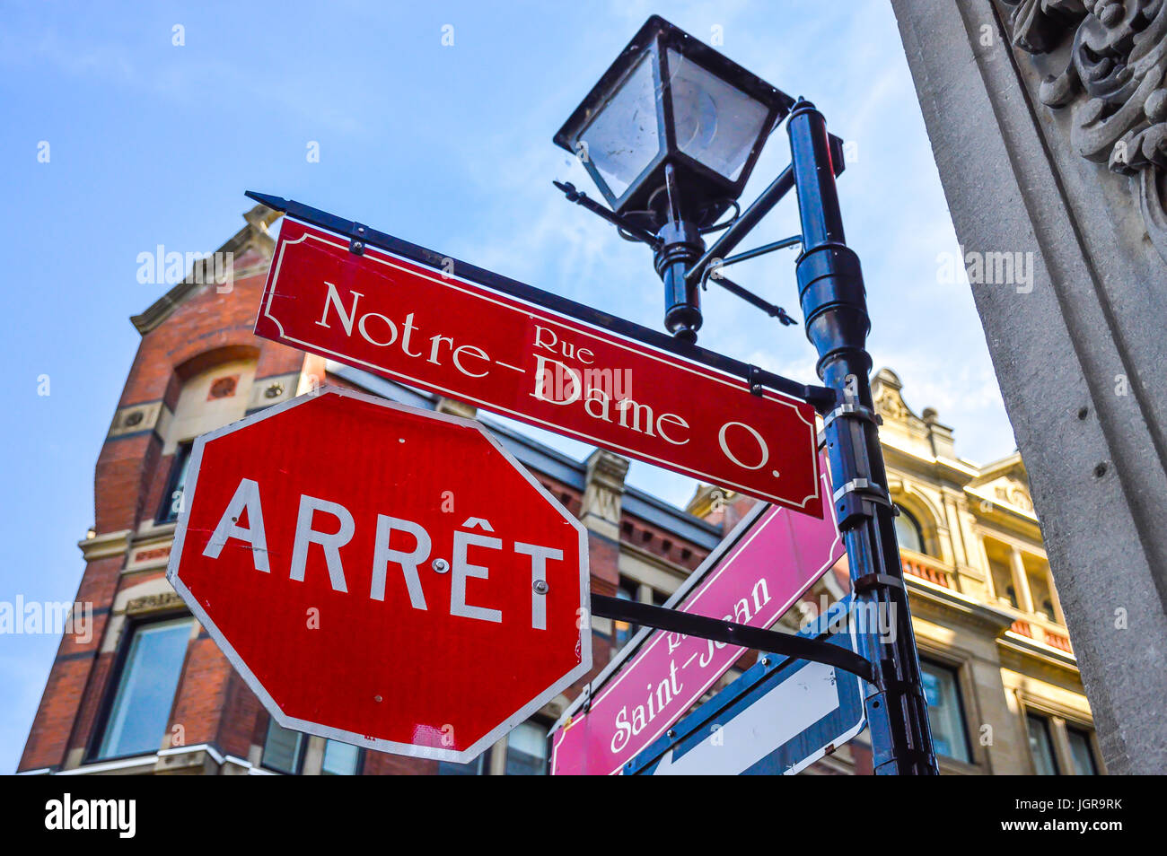 Old lantern and stop sign on Notre-dame street,  in Old Port of the historical quarter in Montreal, Canada. The translation is 'street' and 'Stop'. Stock Photo