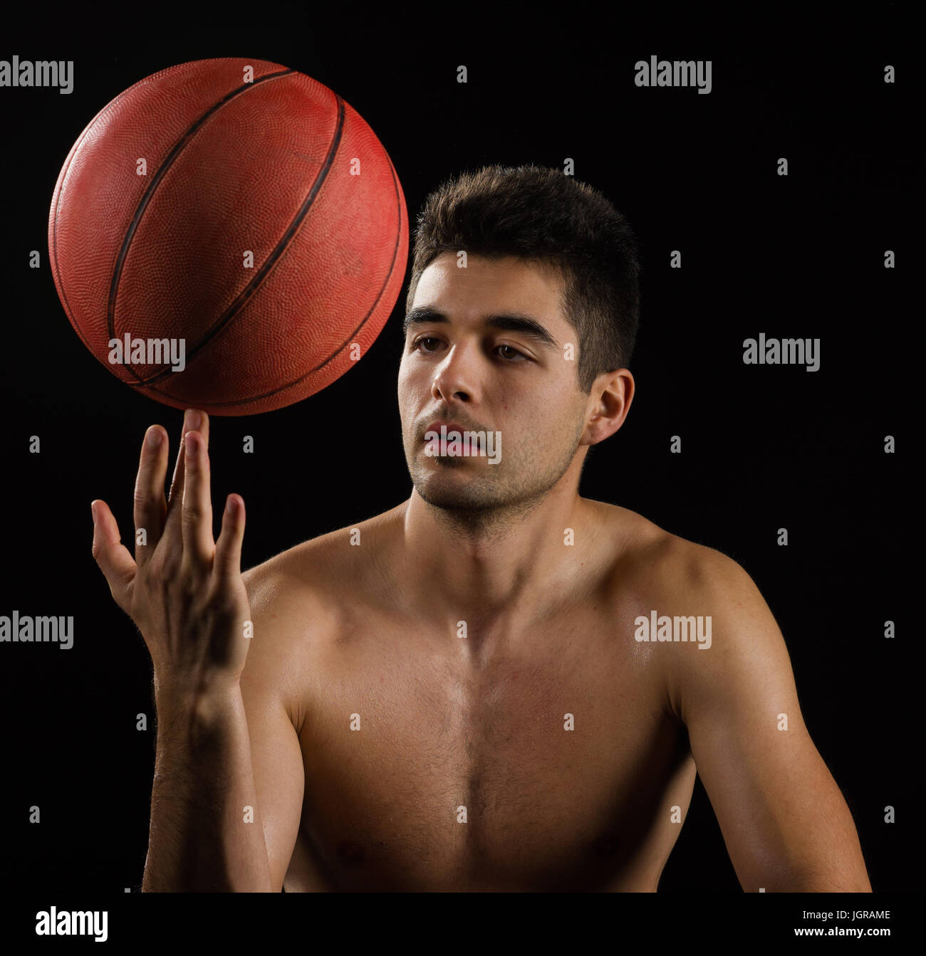 Isolated image of a basketball player spinning a ball on finger Stock