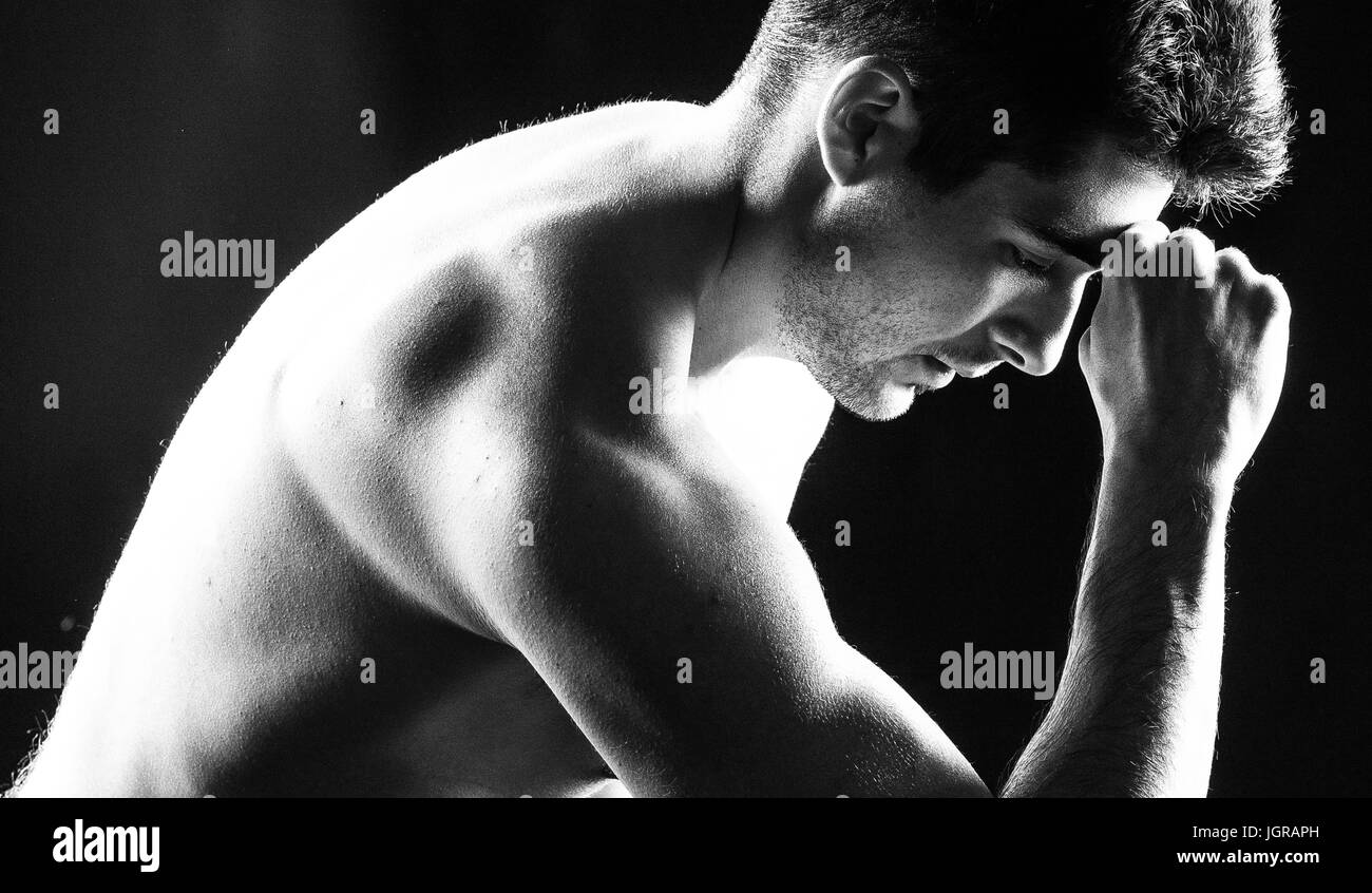 Dramatic close-up of a man thinking with a fist on his forehead Stock Photo