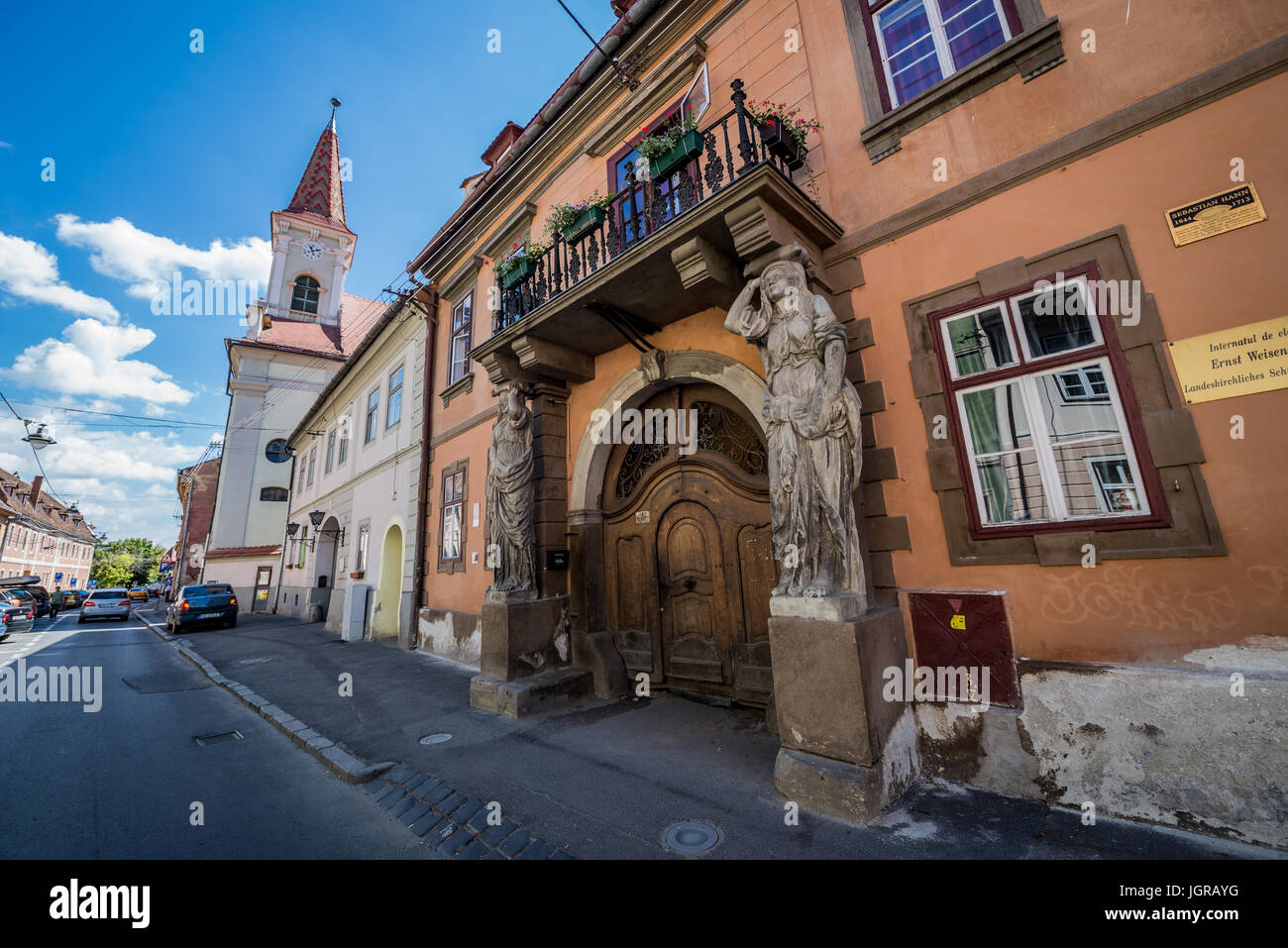 House with Caryatides (Casa cu Cariatide) on Mitropoliei Street in Historic Center of Sibiu city, Romania. Reformed Church on background Stock Photo