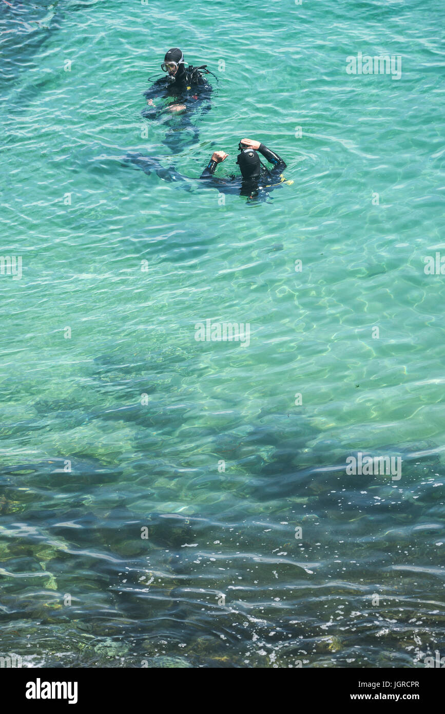 Scuba divers in the sea preparing for a dive. Stock Photo