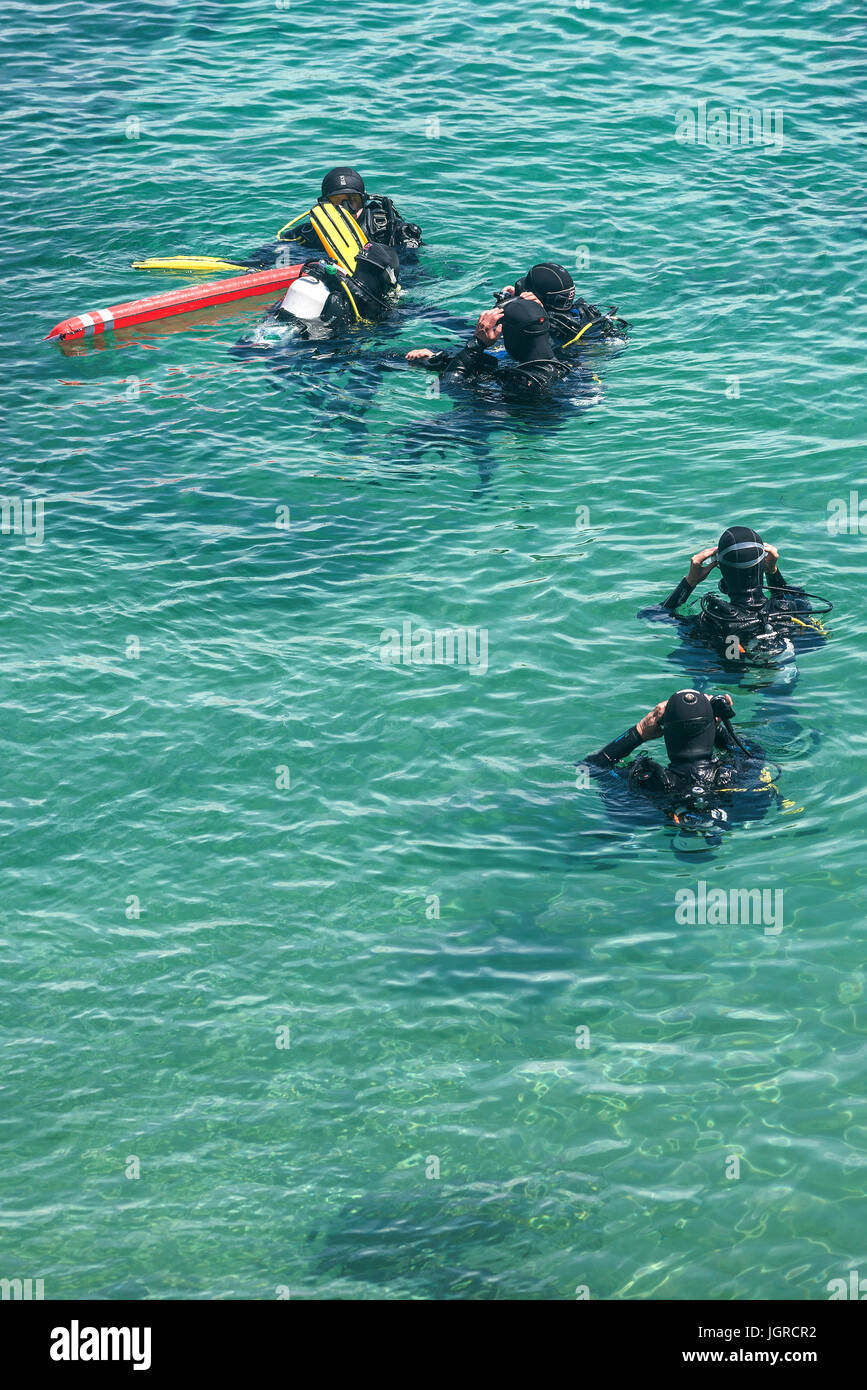 Scuba divers in the sea preparing for a dive. Stock Photo