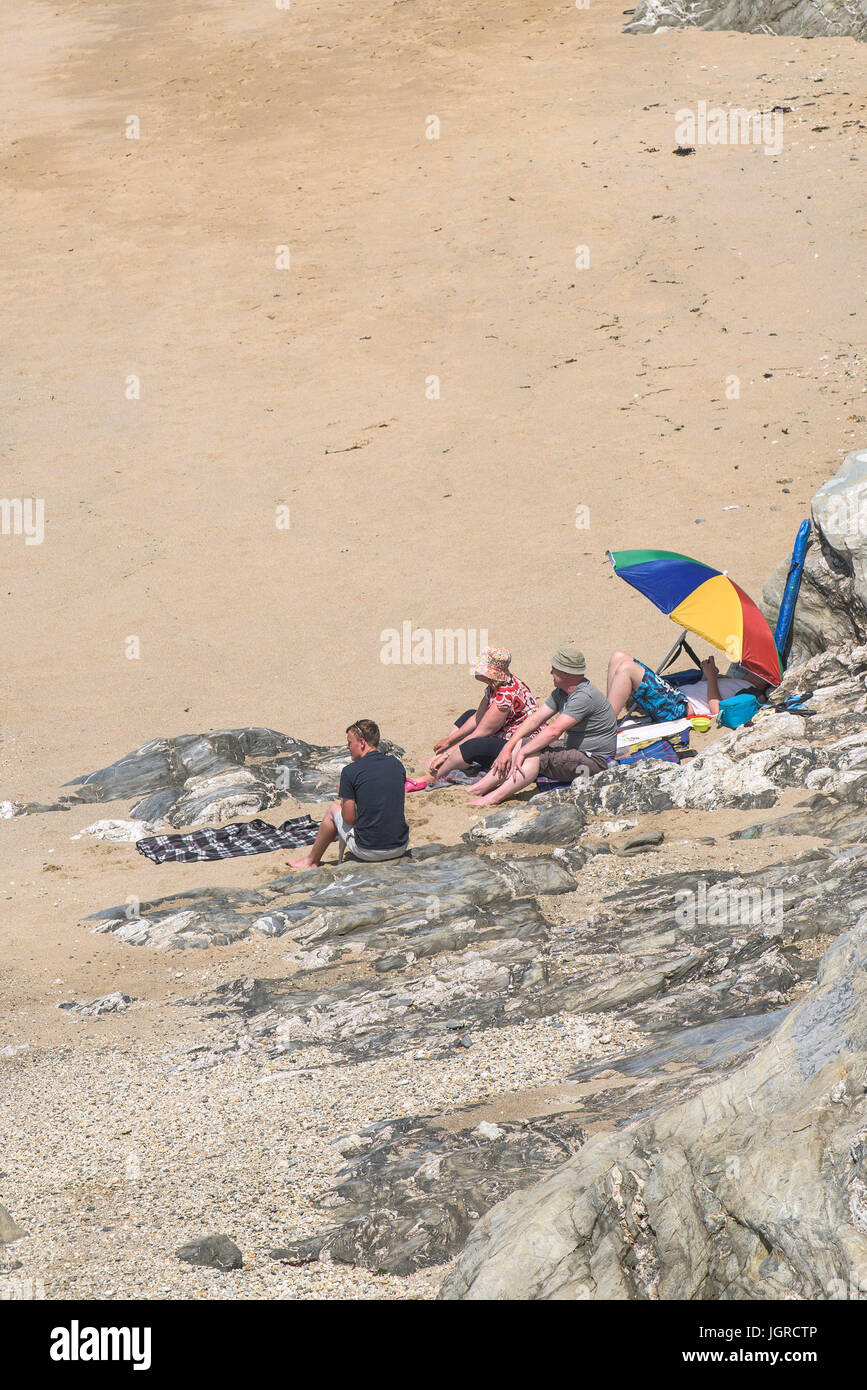 Holidaymakers enjoying the sunshine on the secluded Little Fistral Beach in Newquay, Cornwall. Stock Photo