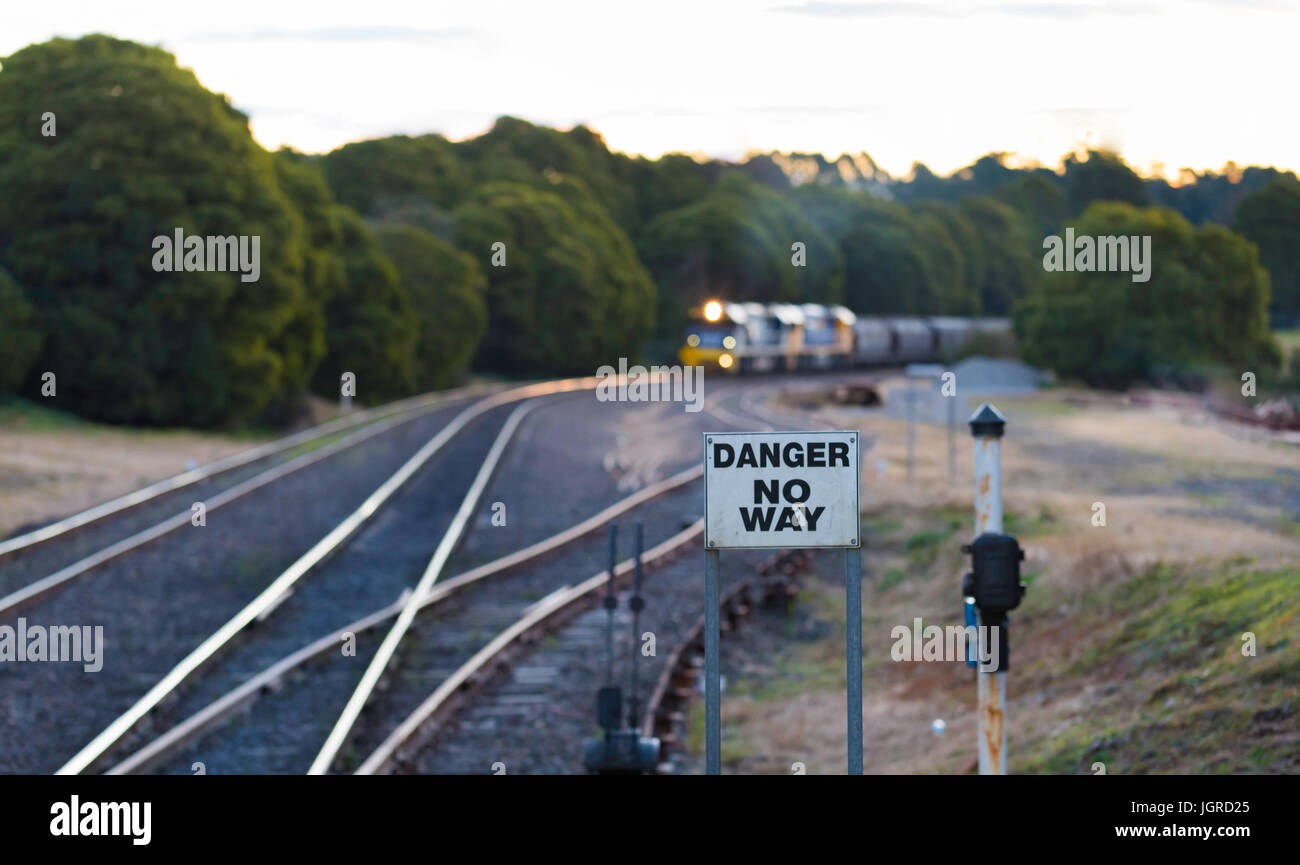 A diesel locomotive pulling coal trucks or wagons through the Southern Highlands of New South Wales in Australia in the early evening for export Stock Photo