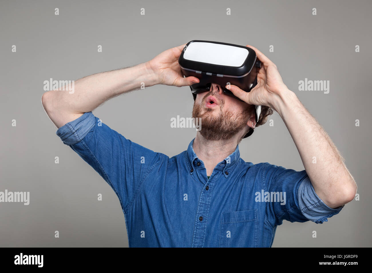Man wearing virtual reality goggles, shot on grey Stock Photo - Alamy