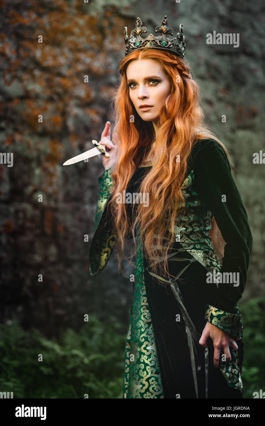 Red-haired woman in a green medieval dress near the castle Stock Photo -  Alamy