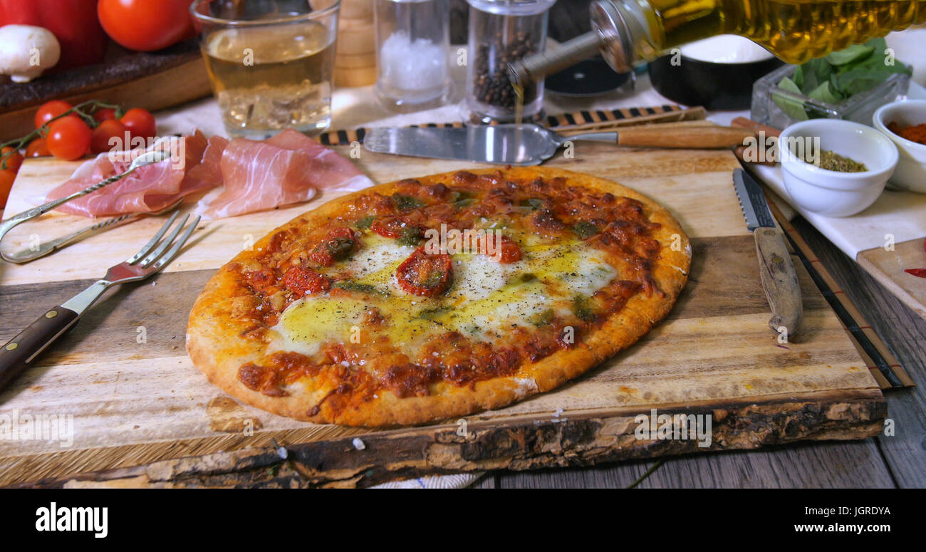 Pouring olive oil over an Italian pizza margherita Stock Photo Alamy