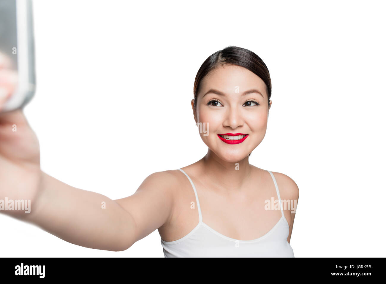 Beautiful asian woman with retro makeup with red lips taking selfie photo isolated on white background. Stock Photo