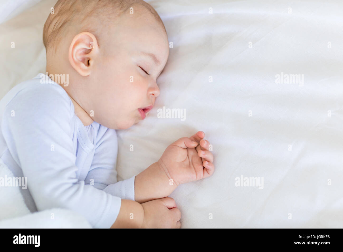 Close-up portrait of adorable baby boy sleeping in bed, 1 year old baby concept Stock Photo