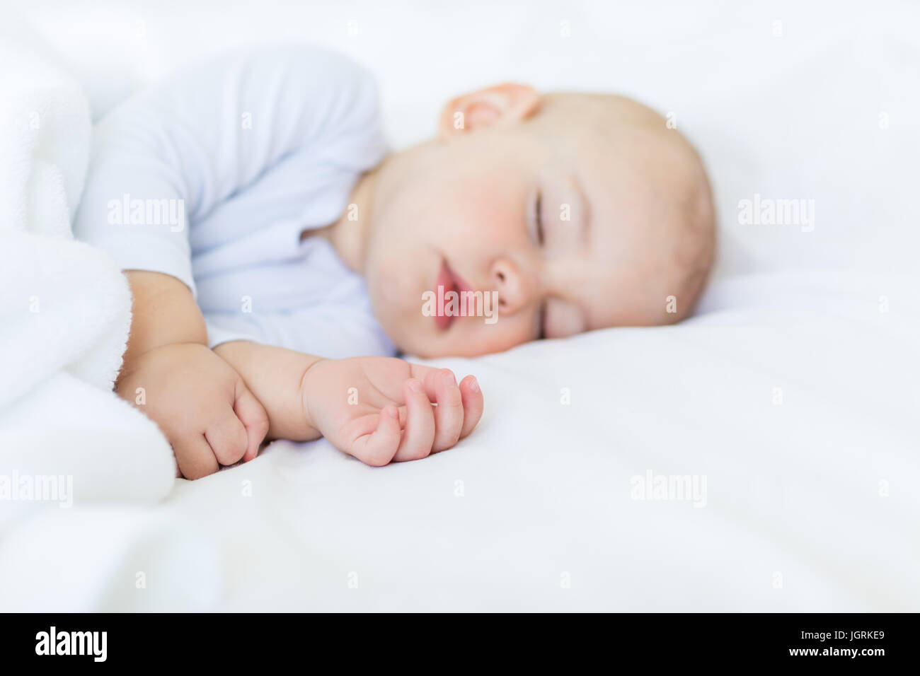 Close-up portrait of adorable baby boy sleeping in bed, 1 year old baby concept Stock Photo
