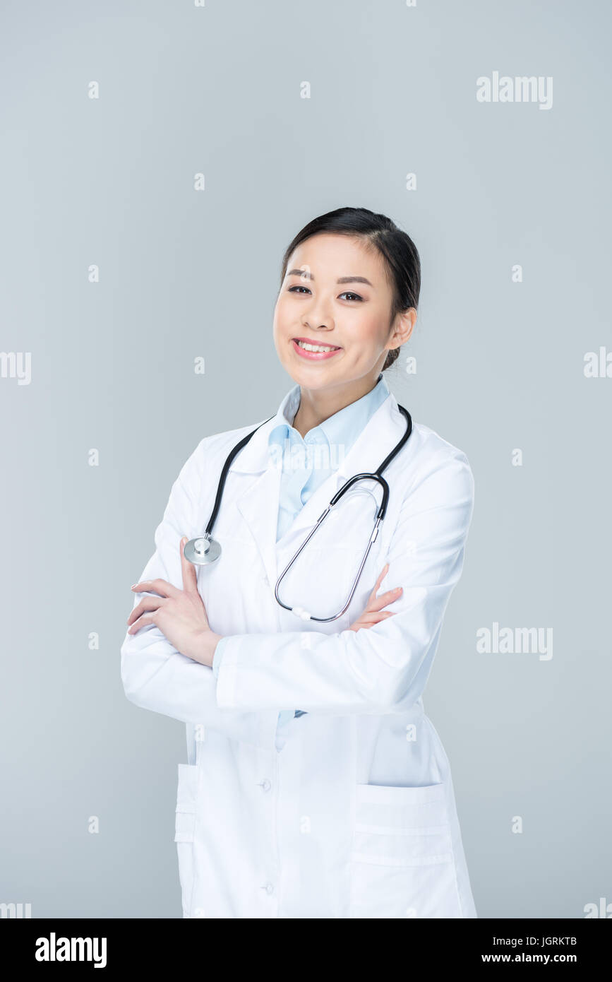 portrait of smiling doctor with arms crossed looking at camera isolated ...