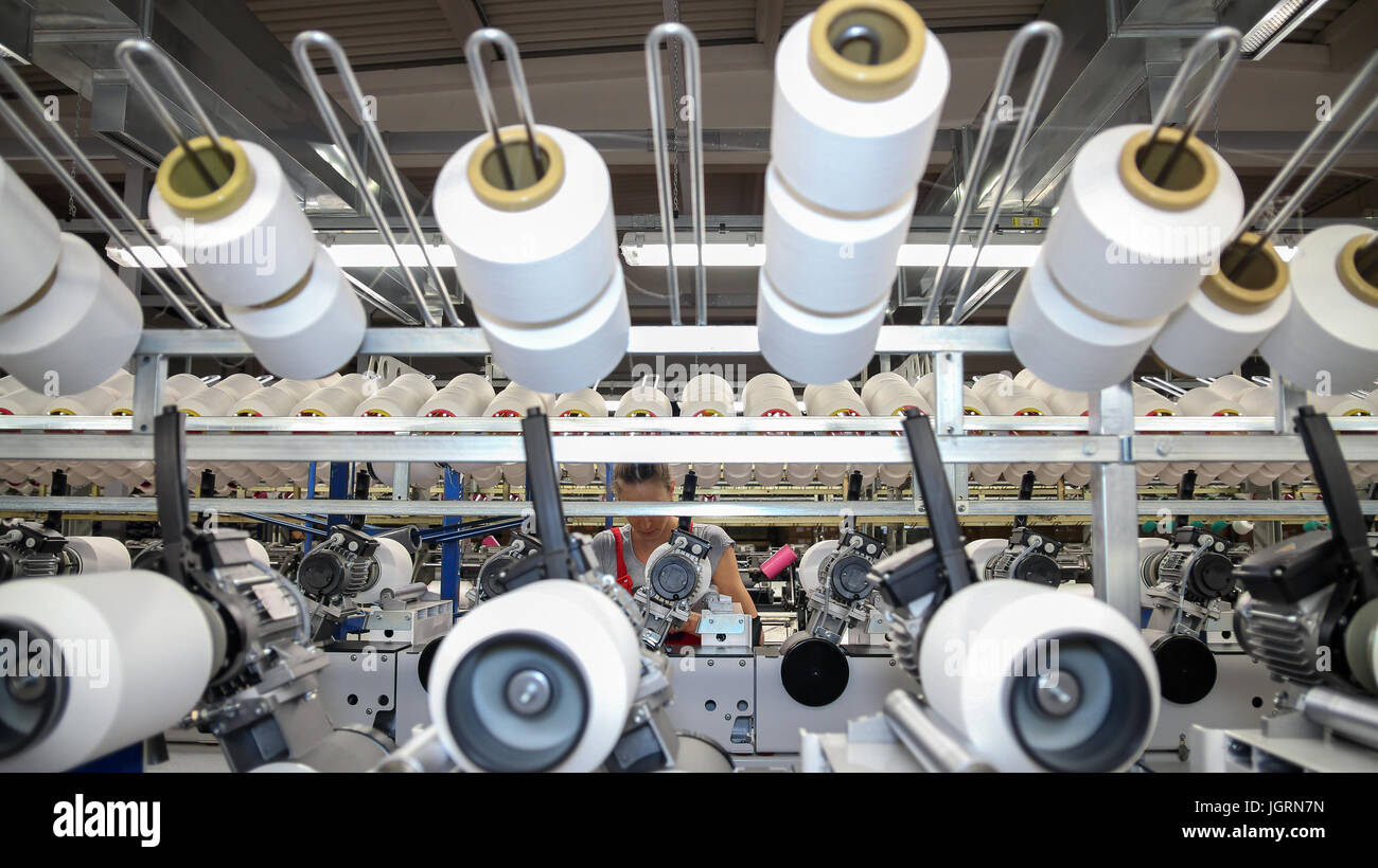 Textile industry. Rows of automated machines for yarn manufacturing. Modern Textile Plant. Textile manufacturing of synthetic fibers. Stock Photo