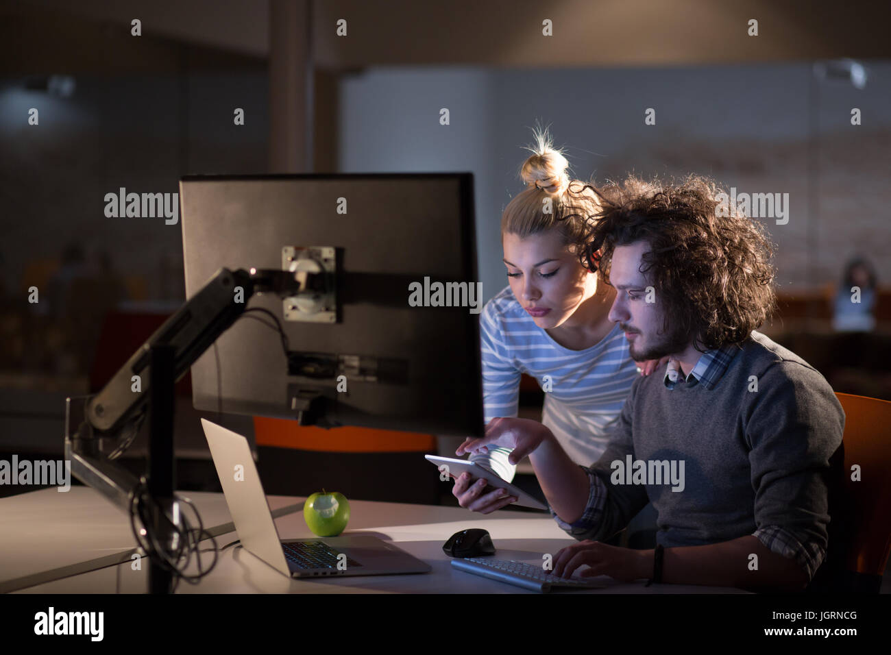 Two young designers are working on a new project in the night office ...