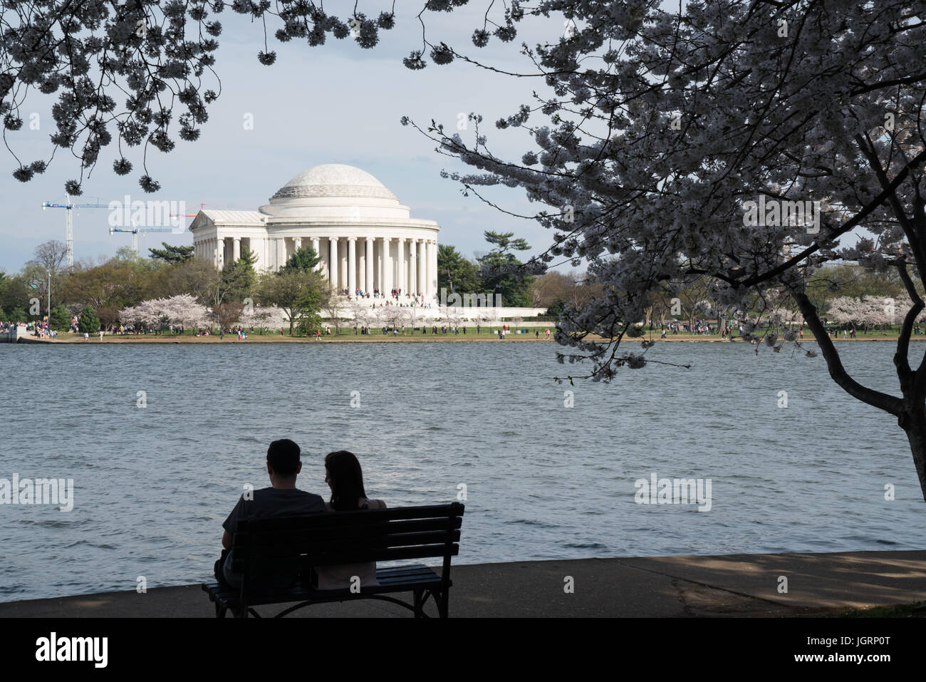 Silhouette of a couple on a bench near the Jefferson Memorial during the Washington DC Cherry Blossom Festival Stock Photo