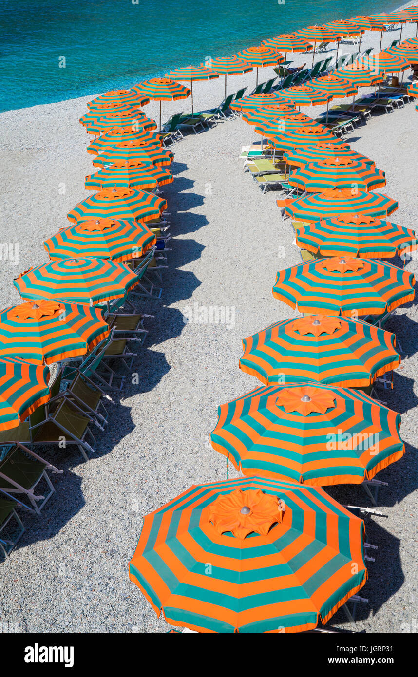Rows of orange & green umbrellas on the beach Stock Photo