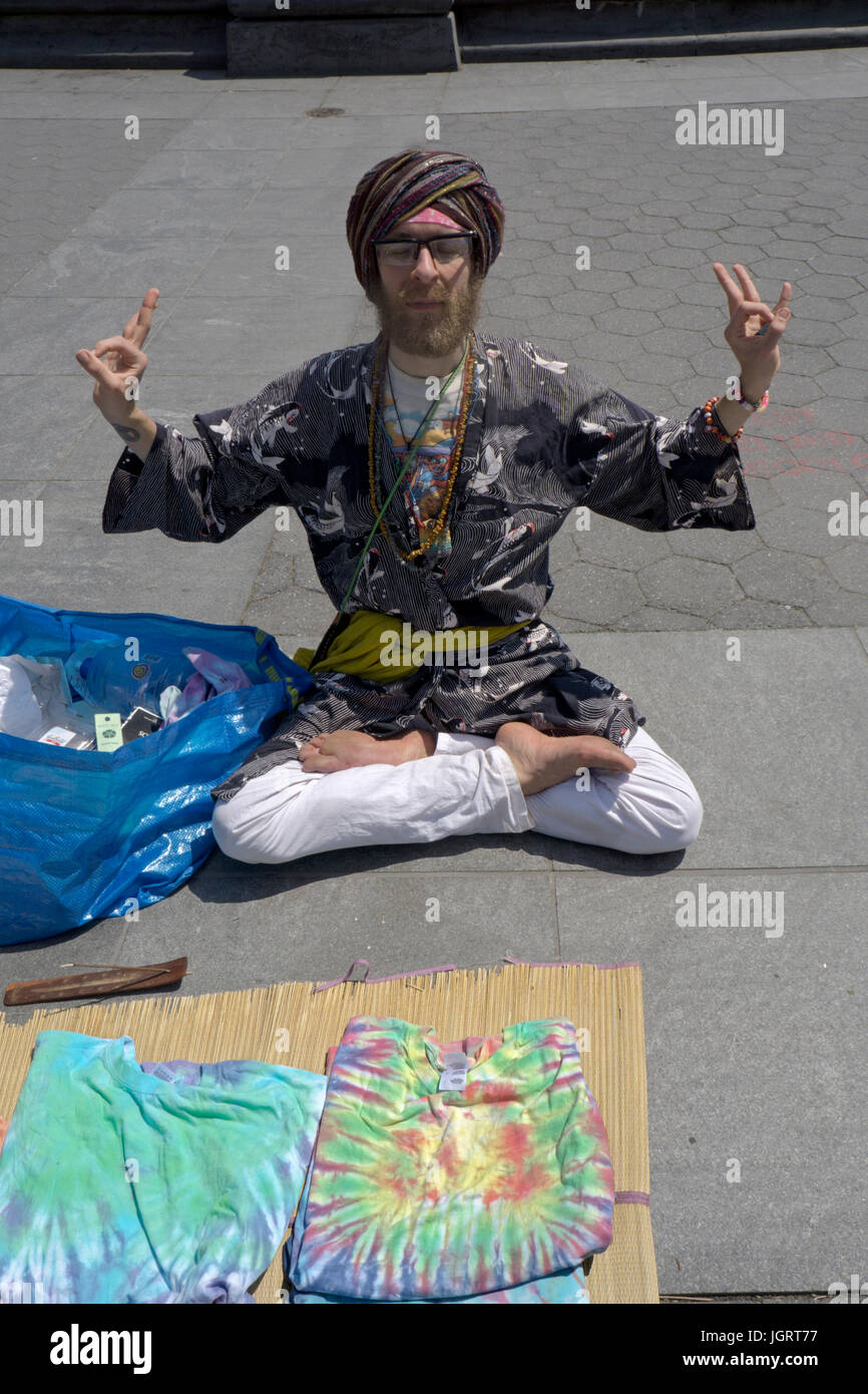 An eccentric New Yorker dressed as a swami selling Indian fashions and incense in Washington Square Park in Greenwich Village, New York City. Stock Photo