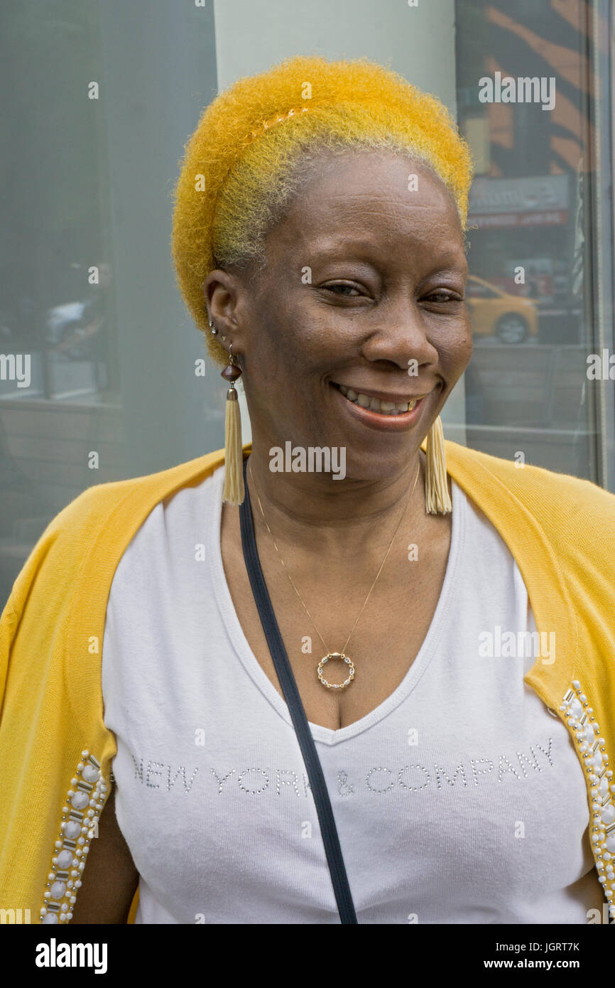 Posed portrait of a woman in her sixties with yellow and orange hair. In Greenwich Village, Manhattan, New York City. Stock Photo