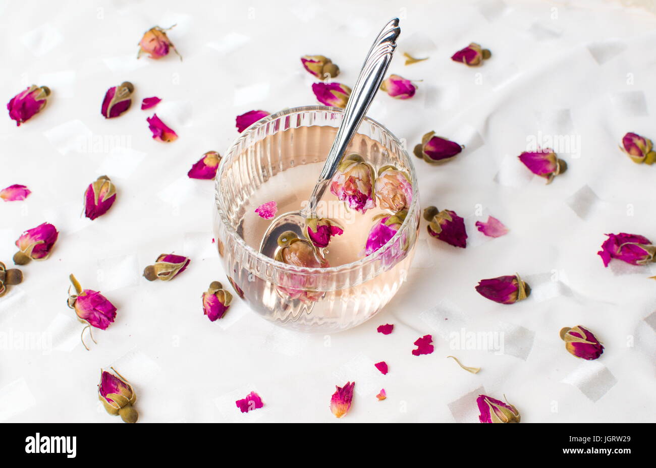 Rose tea in a cup on white fabric Stock Photo