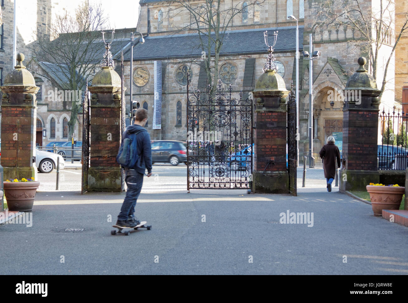 skateboarder on the path out of the botanics gardens  gates Glasgow Stock Photo